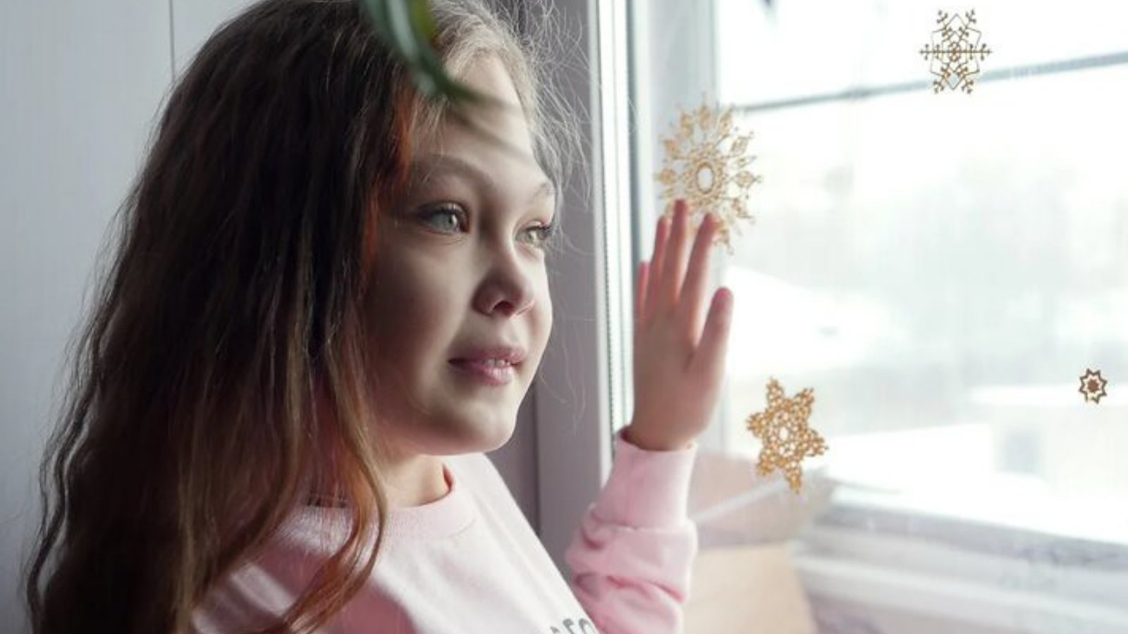 Fotografía de una niña mirando por la ventana.