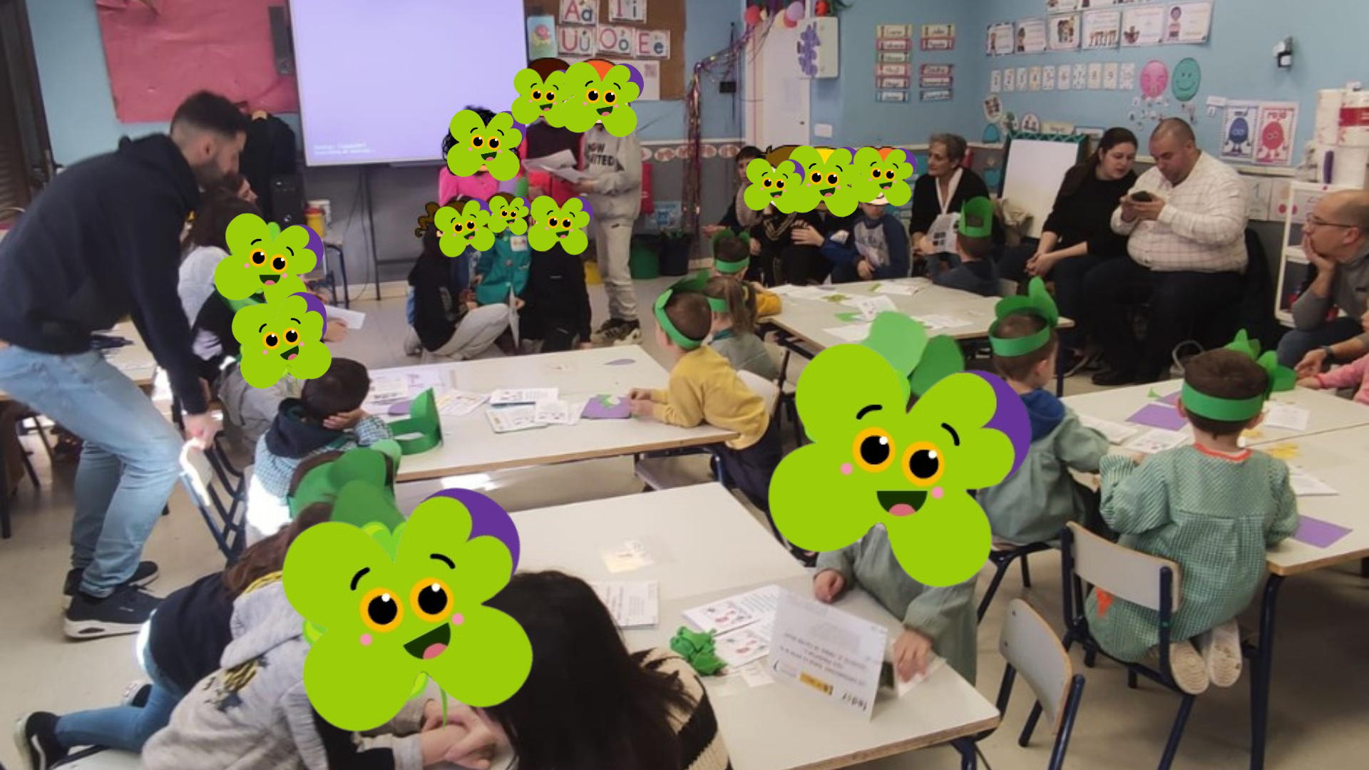 Foto de un grupo de niños y adultos alrededor de una mesa en un aula escolar.