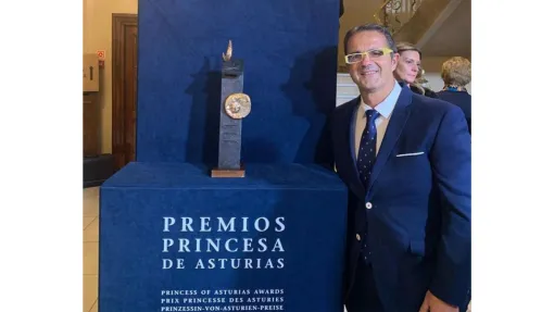 Juan Carrión, presidente de FEDER, posando junto a la imagen de los Premios Princesa de Asturias.